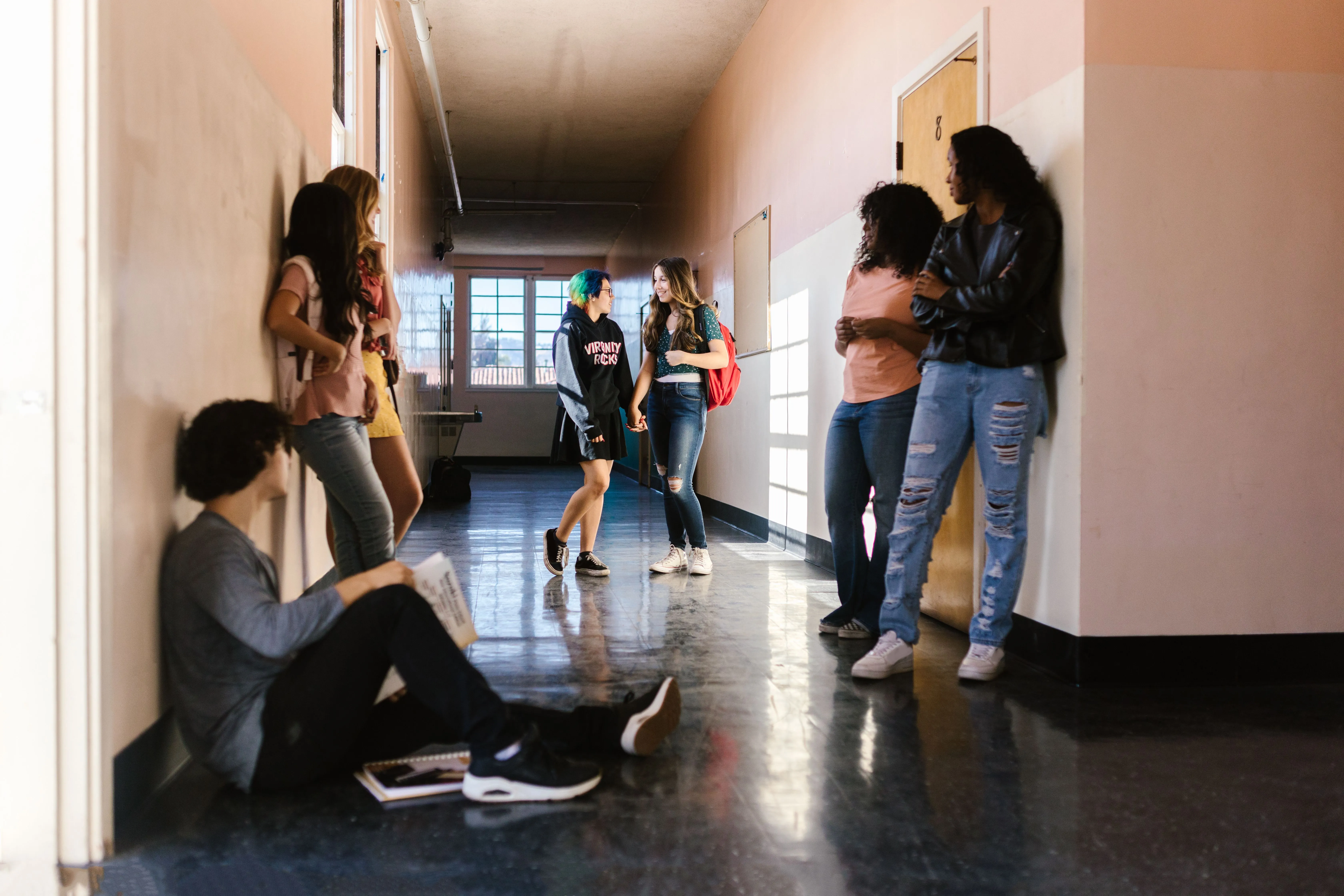 Des lycéens discutent et se retrouvent dans un couloir du lycée entre deux cours.